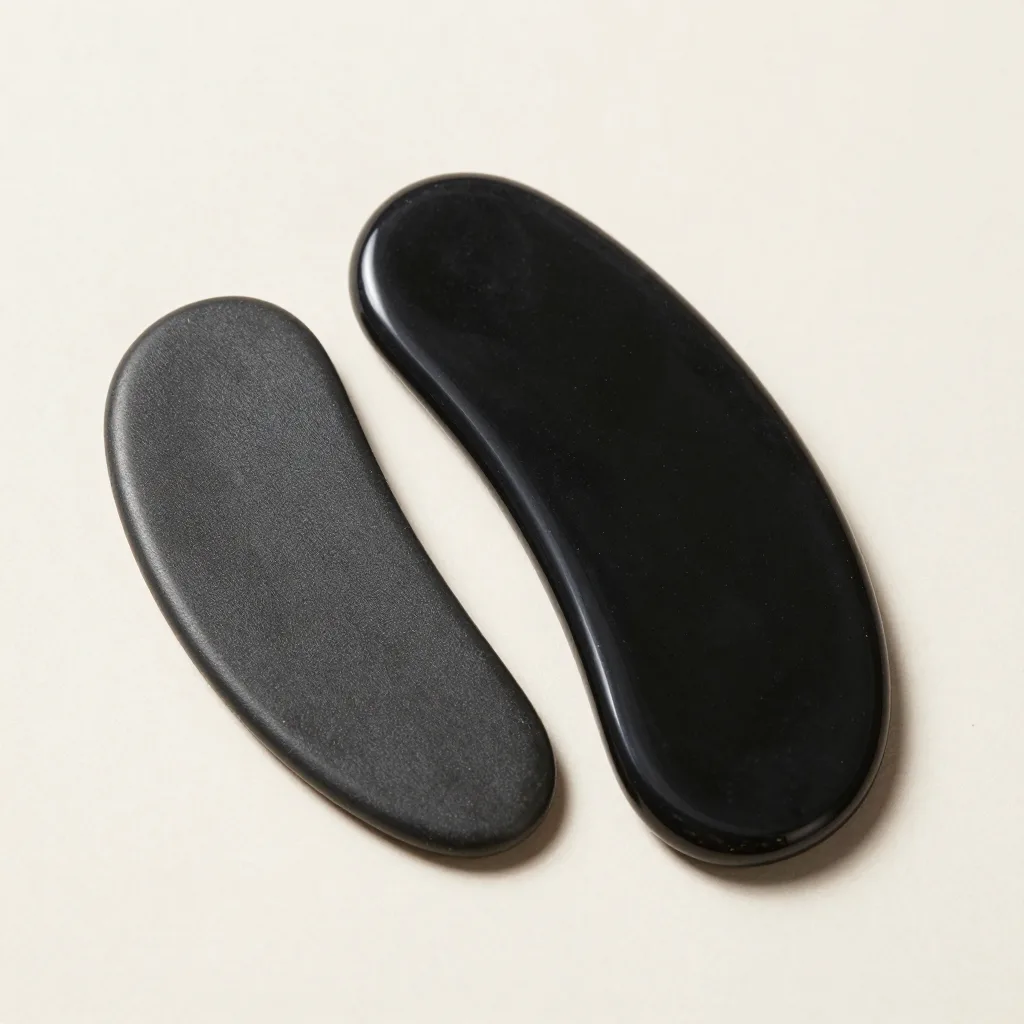 A comb-edged obsidian gua sha board